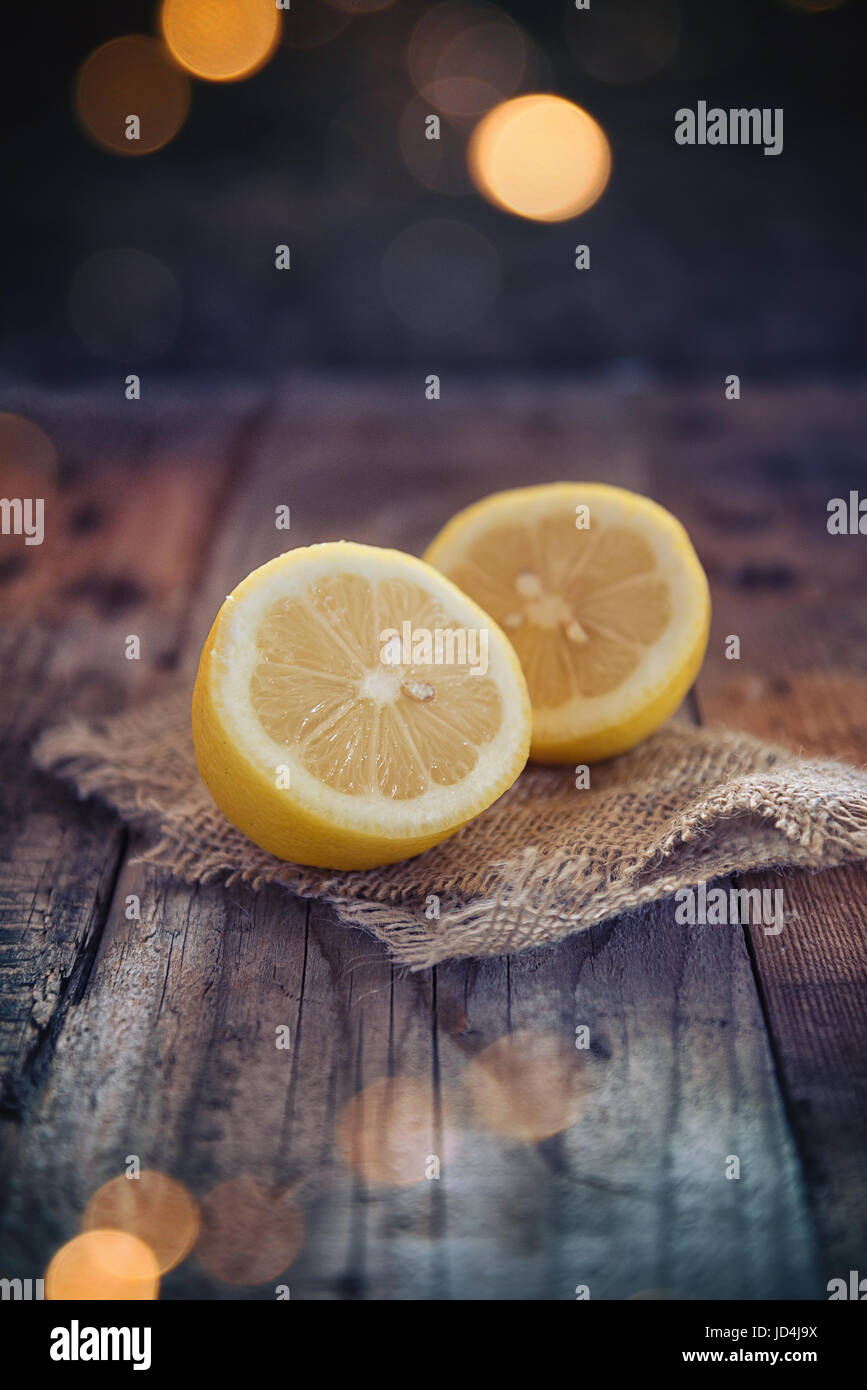Il limone tagliato a metà su assi di legno tabella Foto Stock