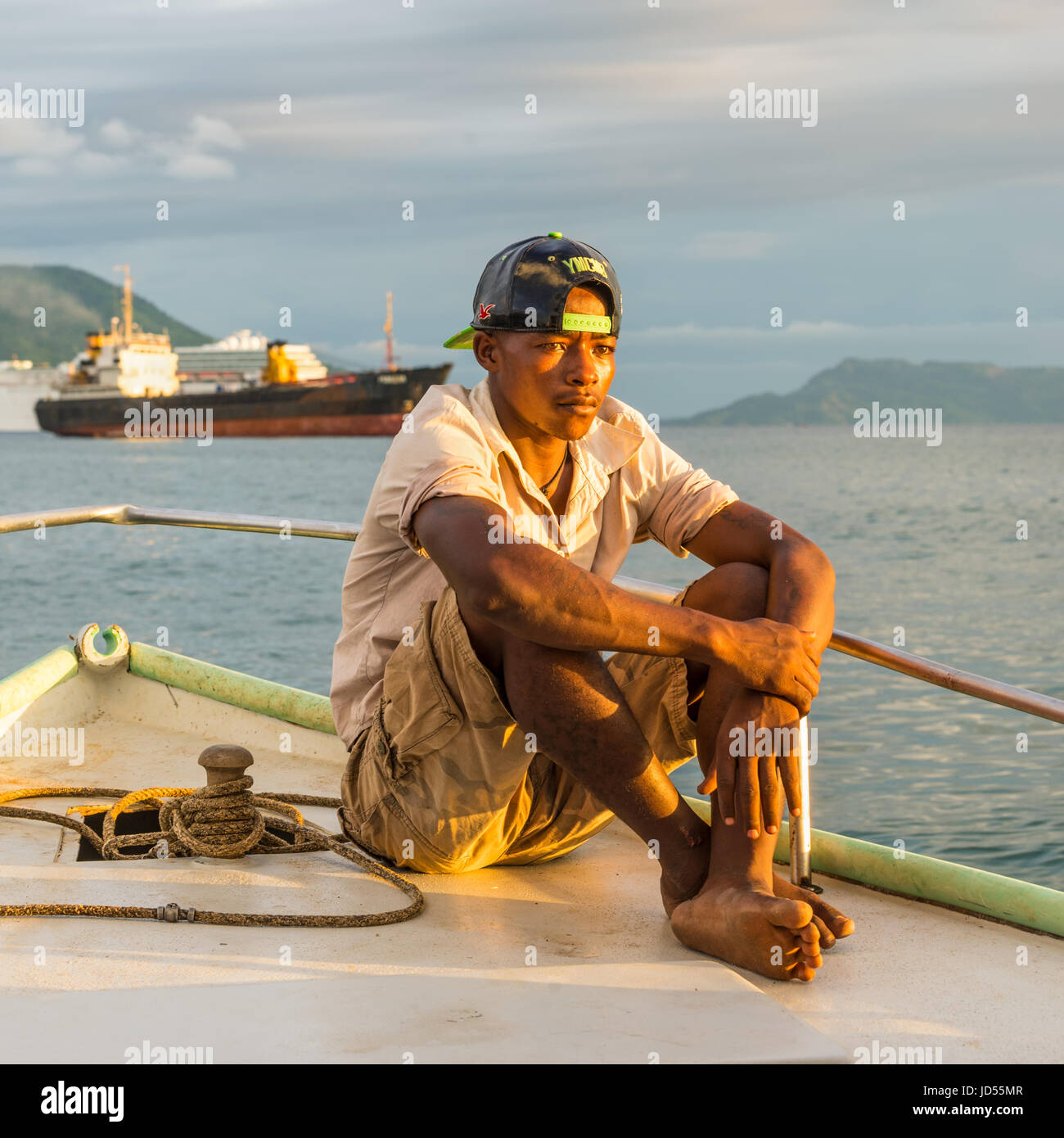 Hell-Ville, Madagascar - 19 Dicembre 2015 : malgascio boatman vela sotto i raggi del sole al tramonto in barca nella baia di Andavakotakona, vicino Hell-Ville Foto Stock