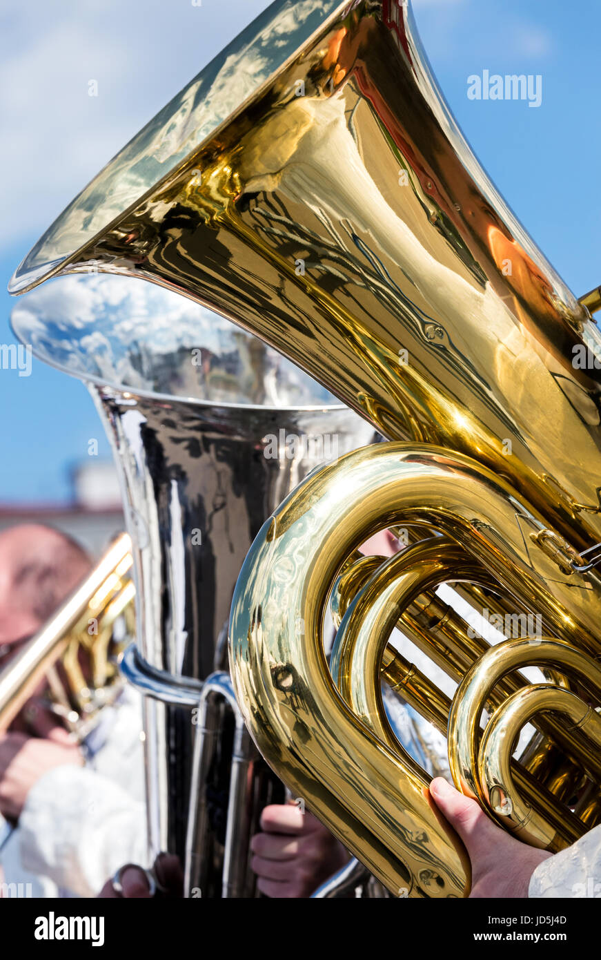 Golden big bass tuba durante il concerto all'aperto contro il cielo blu sullo sfondo Foto Stock