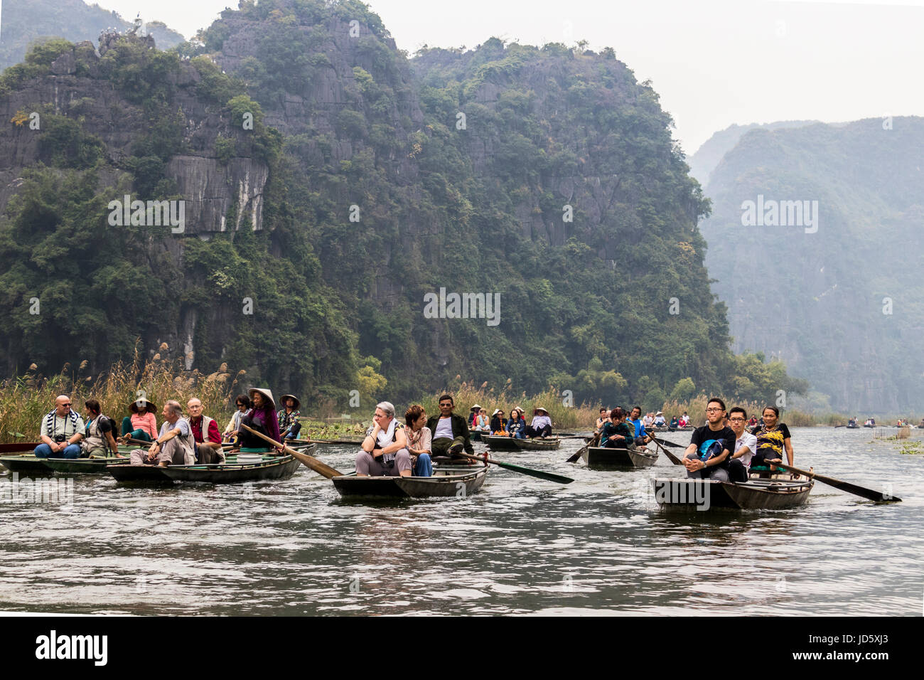 Barca a remi per viaggio turistico a Boi river Tam Coc Vietnam. La maggior parte dei regatanti in queste barche di utilizzare i loro piedi per fare canottaggio piuttosto che le loro mani. Foto Stock