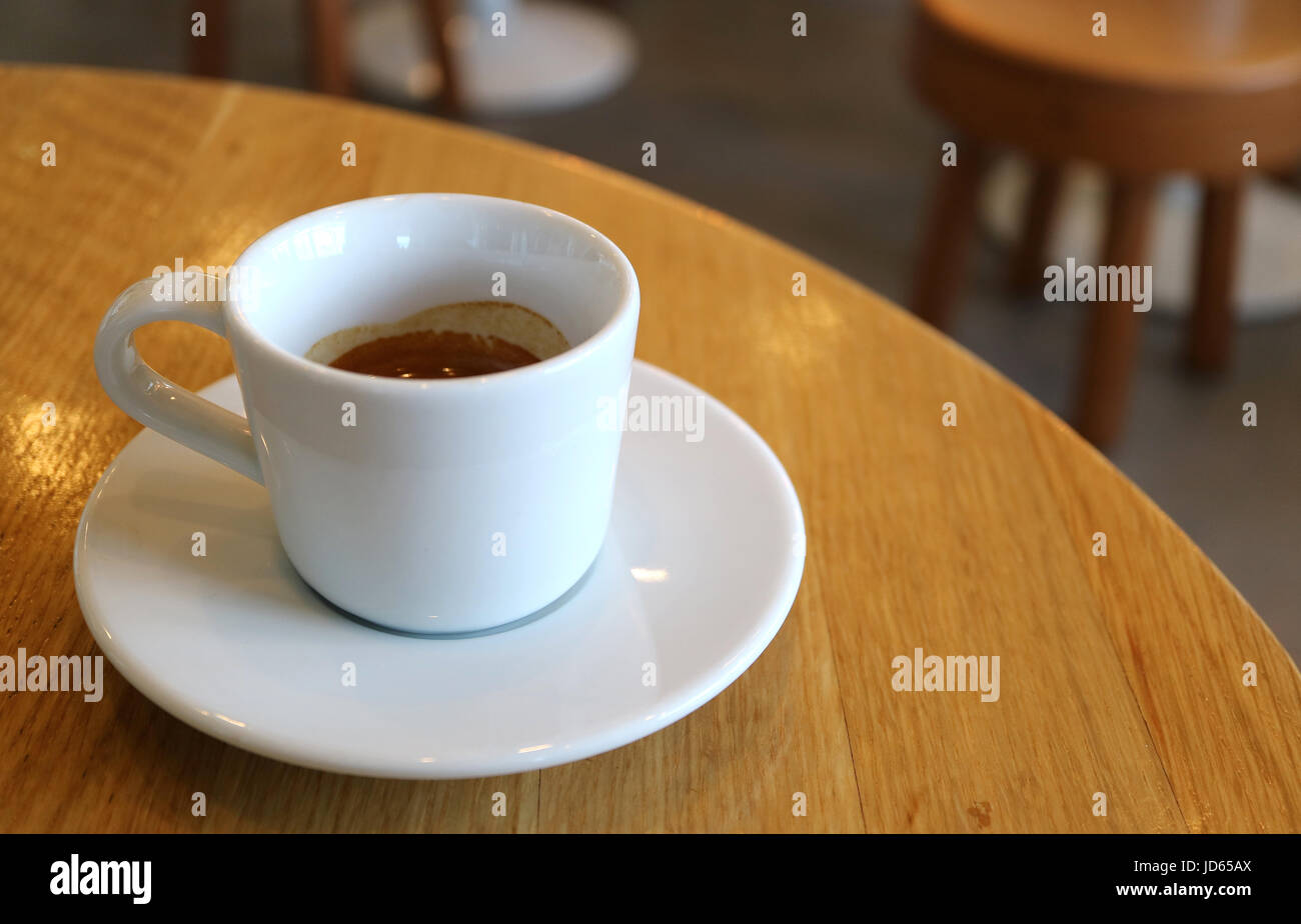 Una tazza di caffè caldo servito su una tavola di legno Tavolo rotondo Foto Stock