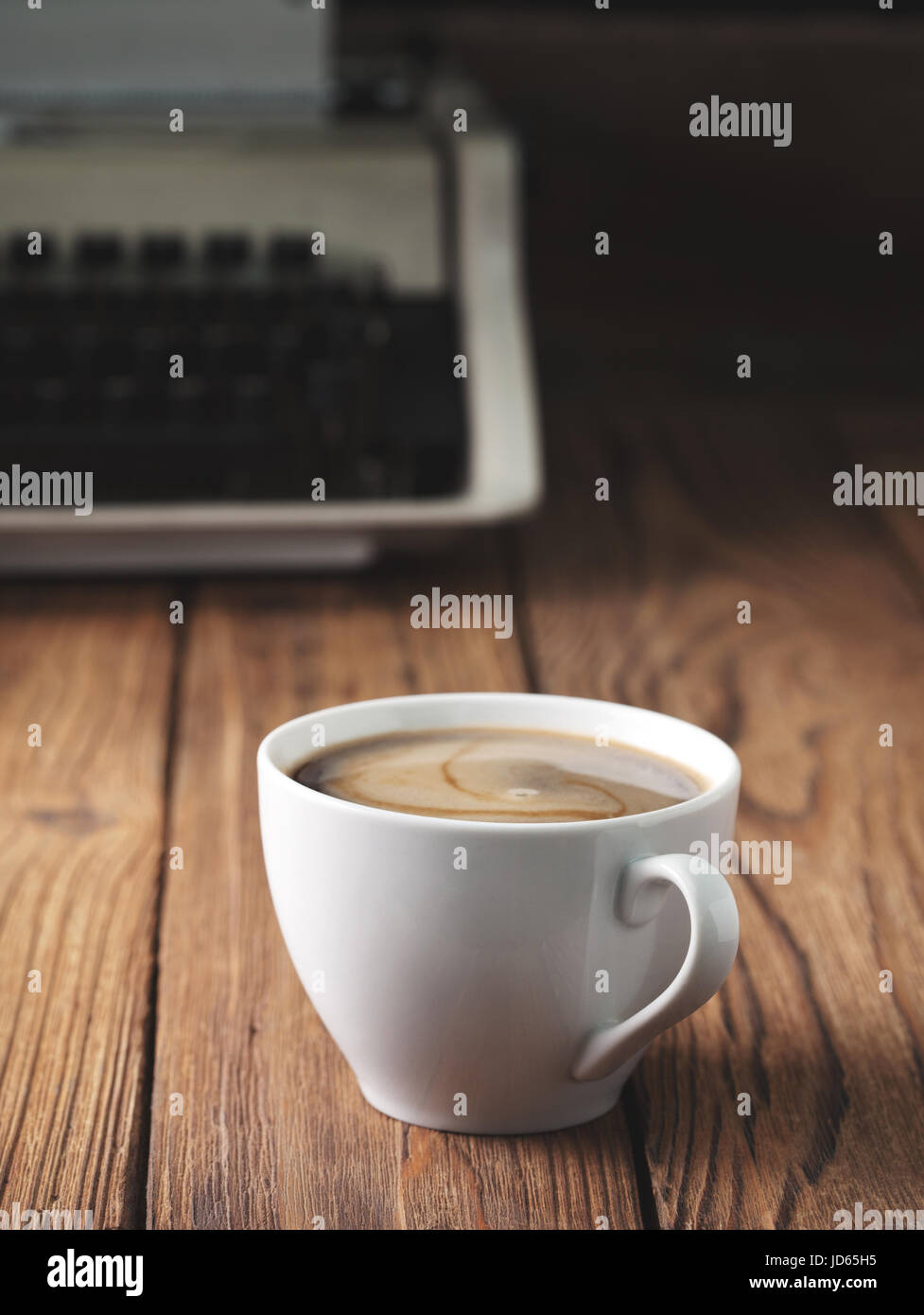 Tazza di caffè e la vecchia macchina da scrivere sul vecchio sfondo di legno. Concetto. Dark. Foto Stock