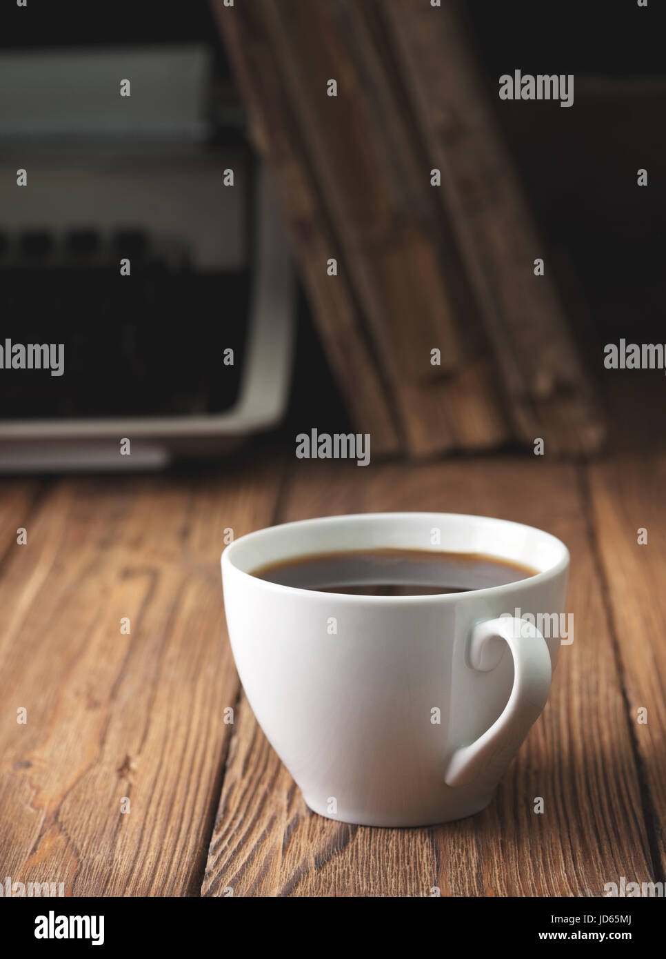 Tazza di caffè e la vecchia macchina da scrivere sul vecchio sfondo di legno. Concetto. Dark. Foto Stock