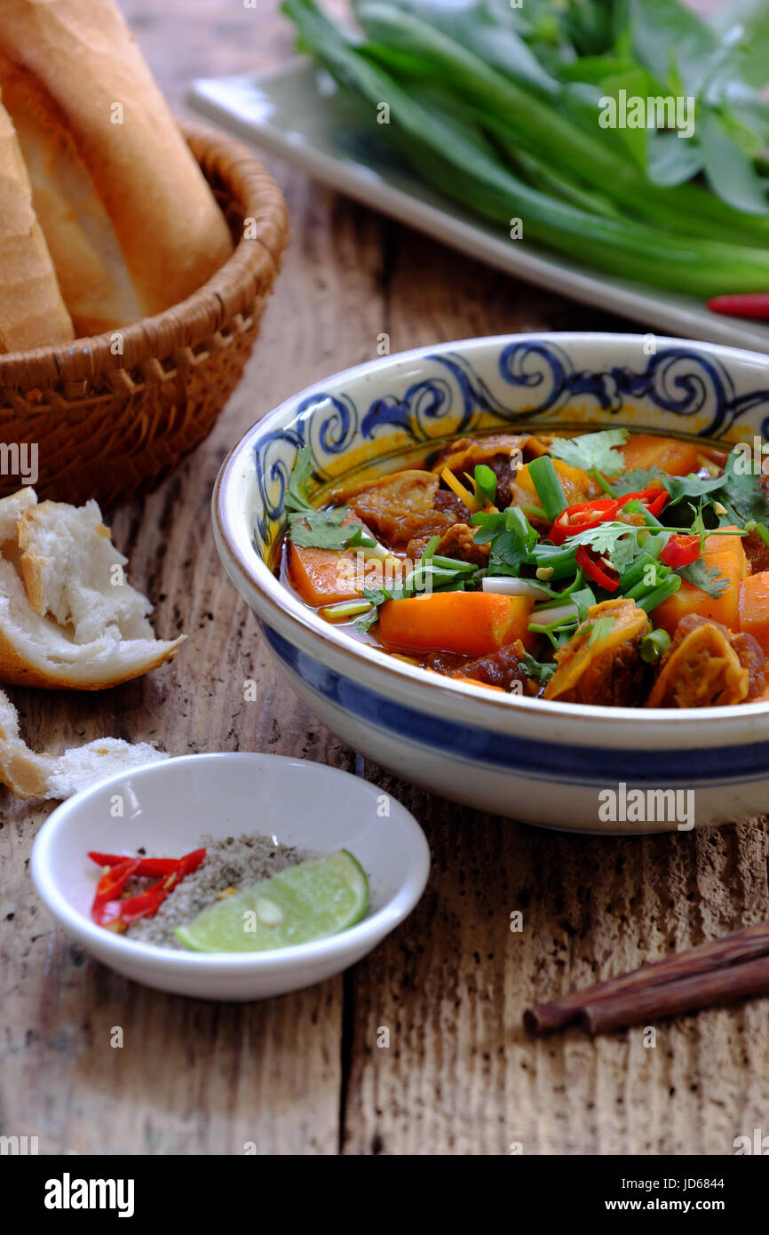 Il Vietnam cibo, pane con stufati di carne di manzo, un popolare pasto al mattino, mangiare allegare il prezzemolo, basilico, limone pepe e sale fare in modo che il sapore delizioso Foto Stock