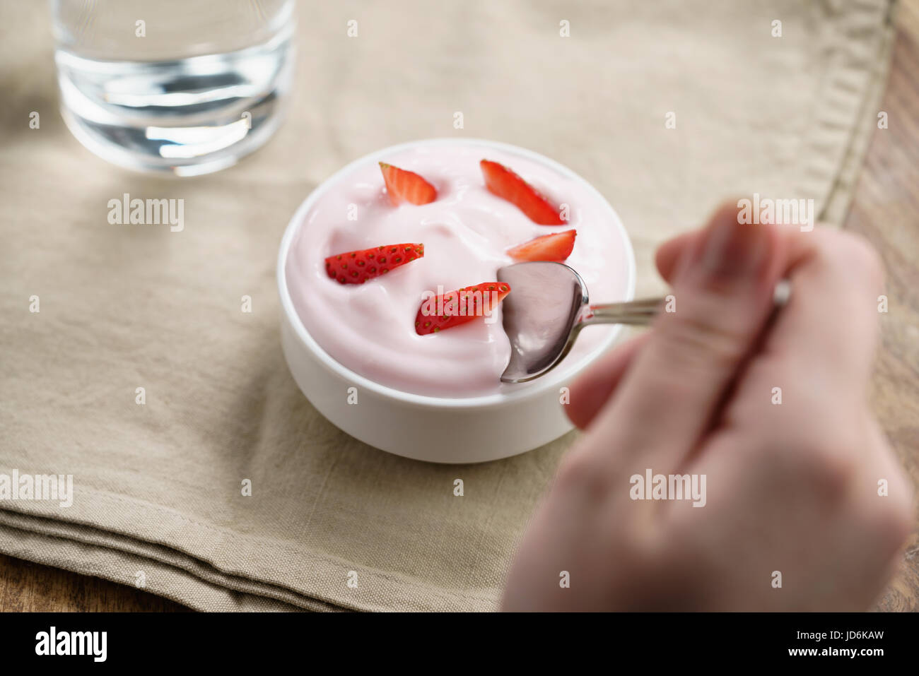 Pov teen ragazza mangiare a mano organici di yogurt alla fragola Foto Stock