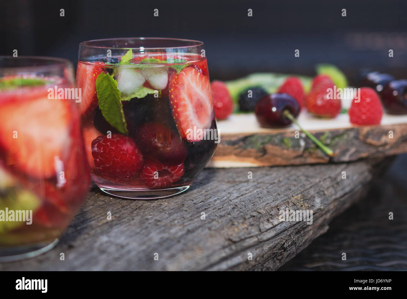 Bicchieri di acqua di frutta con vari ingredienti presentati su un disco ad albero Foto Stock