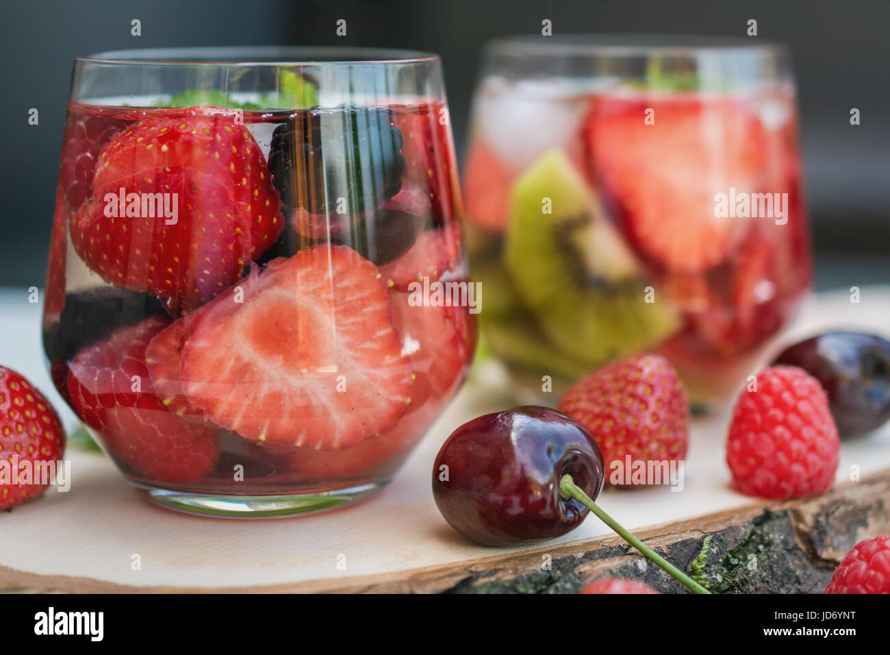 Bicchieri di acqua di frutta con vari ingredienti presentati su un disco ad albero Foto Stock