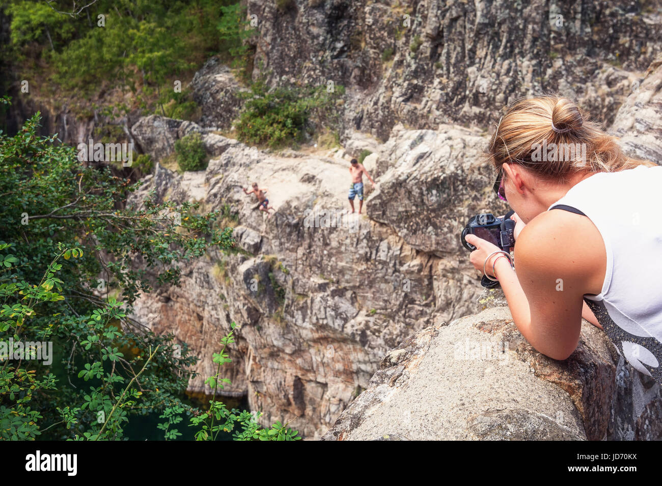 Thueyts, Francia, settembre 11, 2016: fotografo prende la foto del ragazzo che è il salto nel fiume da una roccia. Foto Stock