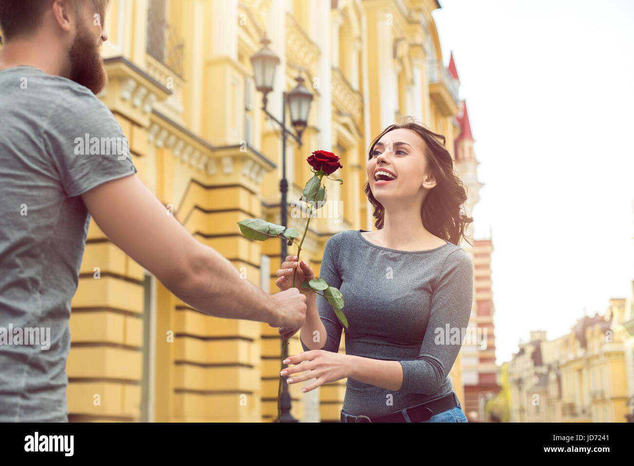 Coppia giovane città a piedi data regalo romantico rose fiore Foto Stock