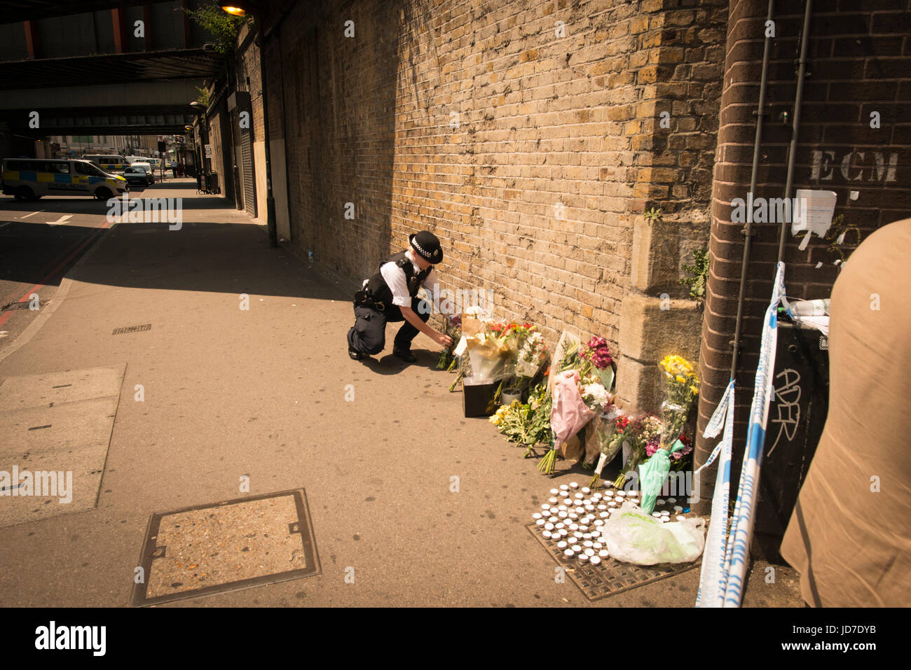 Finsbury Park, London, Regno Unito. 19 giugno 2017. La folla si sono riuniti a seguito di un sospetto attacco terroristico in precedenza questa mattina. Nella foto: una poliziotta luoghi fiori vicino alla scena del crimine. Credito: Byron Kirk/Alamy Live News Foto Stock