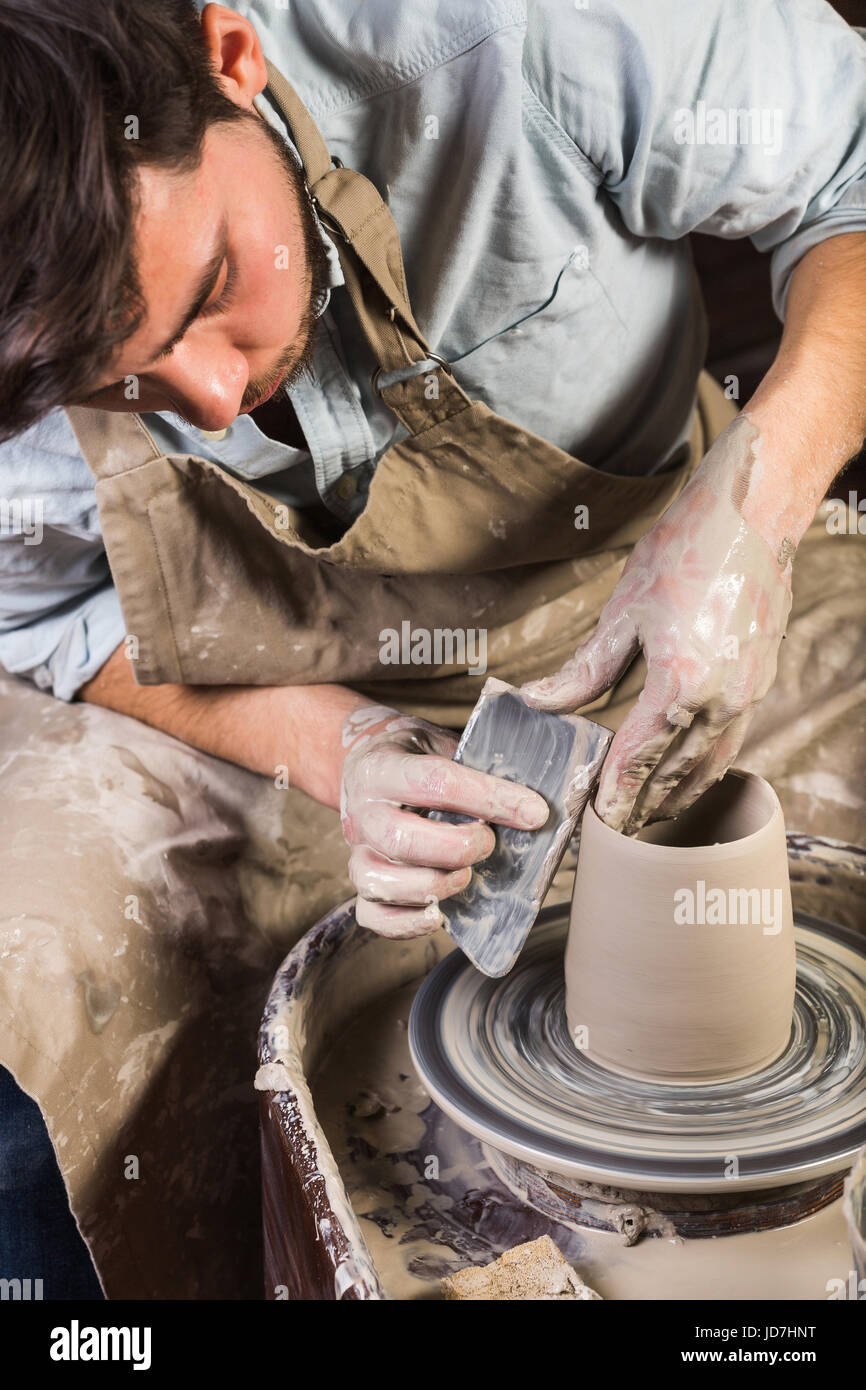 Ceramiche, workshop, arte ceramica concetto - yong maschio scolpire alcuni  nuovi utensili con le mani, strumento, dita e acqua, l'uomo lavora con il  tornio del vasaio e materie in terra refrattaria, messicano,