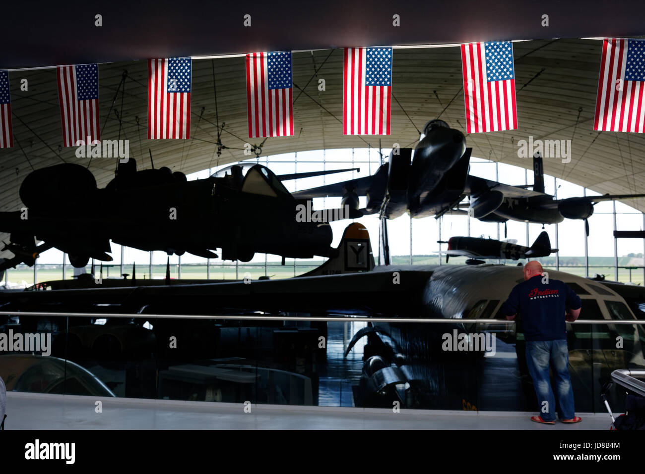 Il Duxford Air Museum di Cambridgeshie, Inghilterra. Il sole illumina la Stars & Stripes in American Air Museum con la F-15 Eagle al di là. Foto Stock