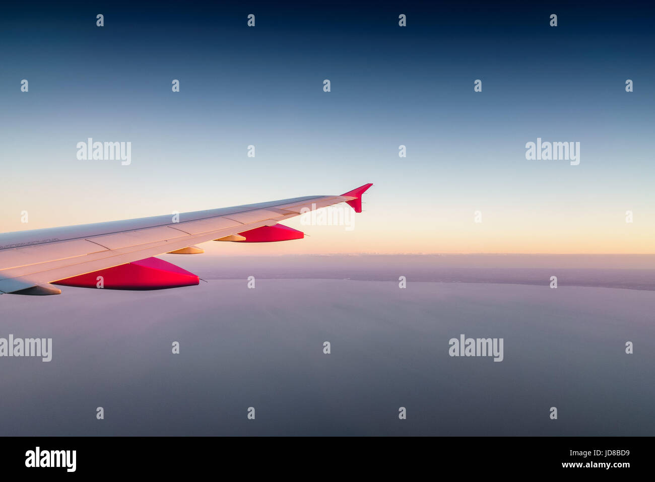 Rosso e bianco di punta ala di aeroplano nel cielo con orizzonte". Foto Stock