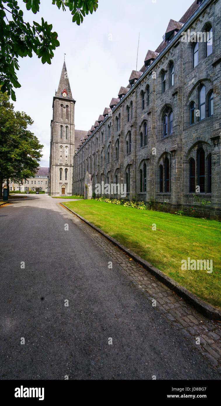 Vuoto viale che conduce alla palazzina con alta torre a cuspide, Belgio Belgio europa Foto Stock