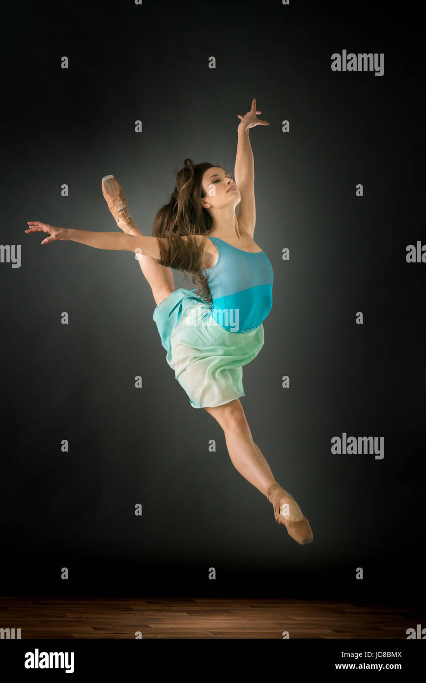 Femmina danzatore di balletto saltando metà aria, braccia tese, studio shot. caucasian montare piuttosto skinny athletic Foto Stock