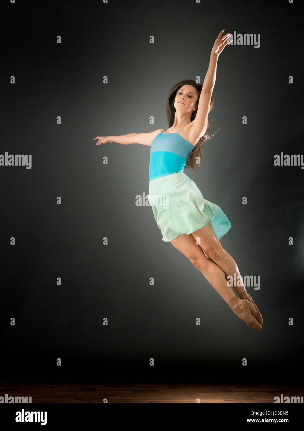 Femmina danzatore di balletto saltando metà aria, le gambe insieme, studio shot. caucasian montare piuttosto skinny athletic Foto Stock