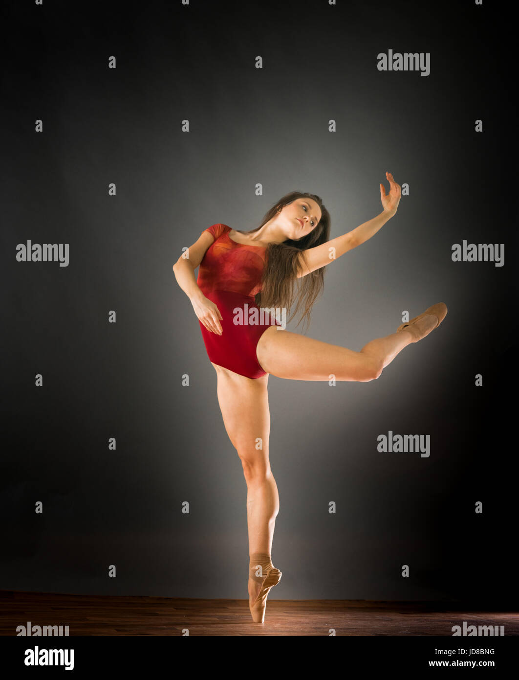 Femmina ballerina su una gamba guardando al lato, studio shot. caucasian montare piuttosto skinny athletic Foto Stock