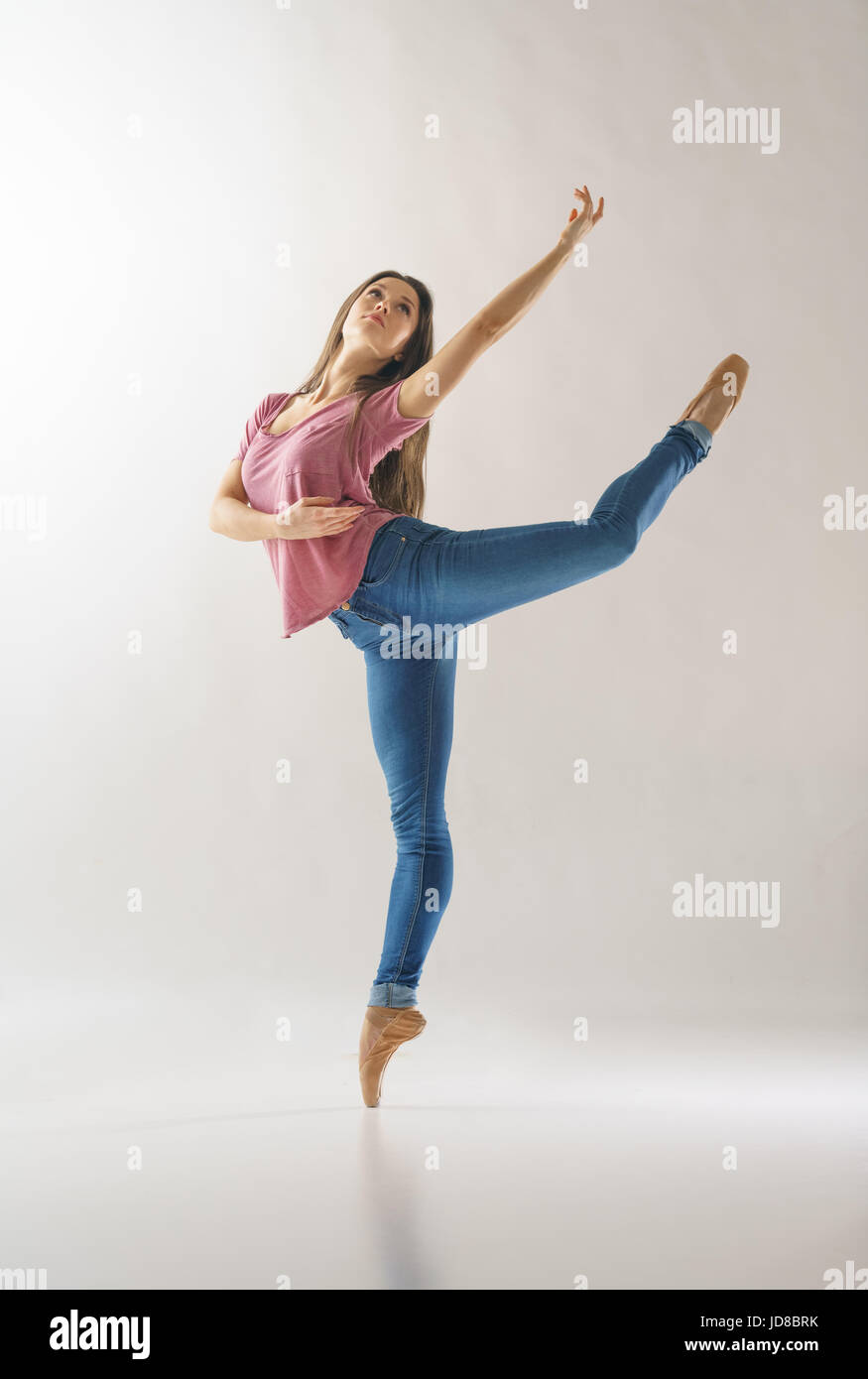 Femmina ballerina su una gamba, indossando un abbigliamento casual, studio shot. caucasian montare piuttosto skinny athletic Foto Stock