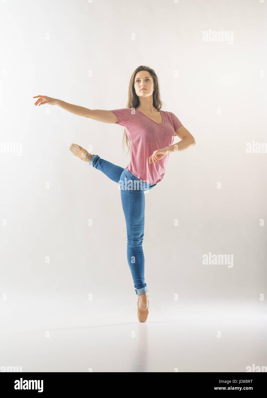 Femmina ballerina su una gamba, indossando un abbigliamento casual, studio shot. caucasian montare piuttosto skinny athletic Foto Stock