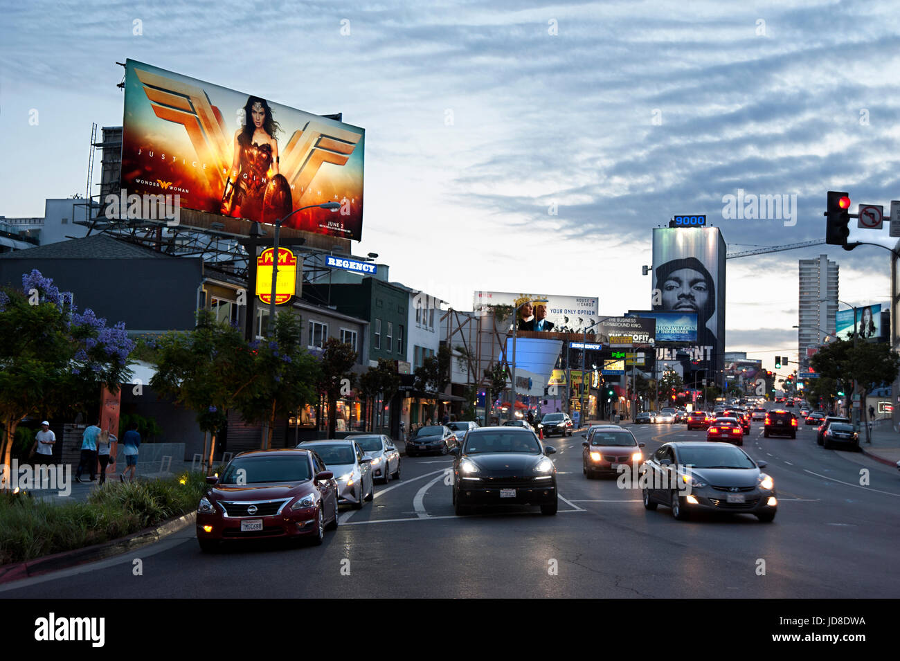 Il Sunset Strip in West Hollywood al crepuscolo con cartelloni pubblicitari illuminati tra cui uno per il film di successo come la donna di meraviglia, Los Angeles, CA Foto Stock