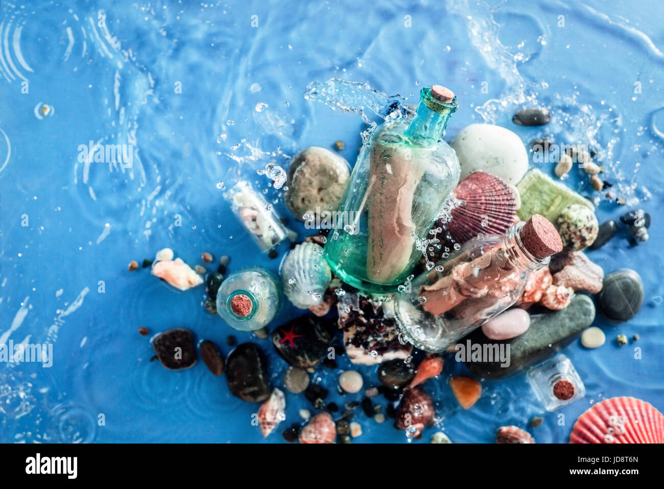 Due bottiglie di vetro con la vecchia carta note su un fondo di acqua con un ripple di seawave, conchiglie, ciottoli e sabbia. underwater ancora in vita. Foto Stock