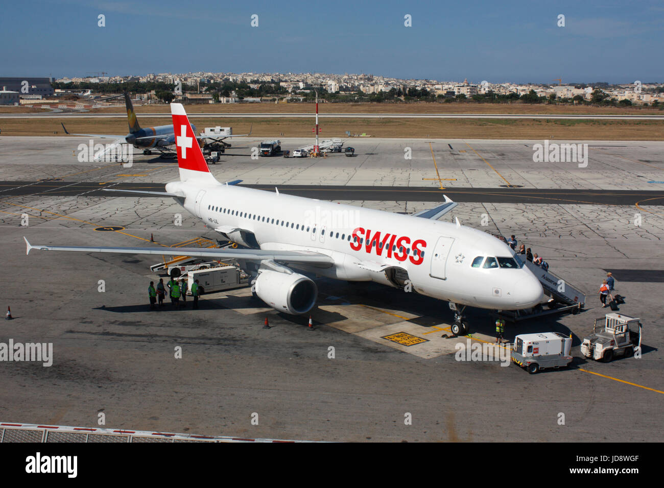 Aria commerciale viaggi in Europa. I passeggeri di salire a bordo di un Swiss International Air Lines Airbus A320 piano a getto sul piazzale dell'Aeroporto Internazionale di Malta Foto Stock