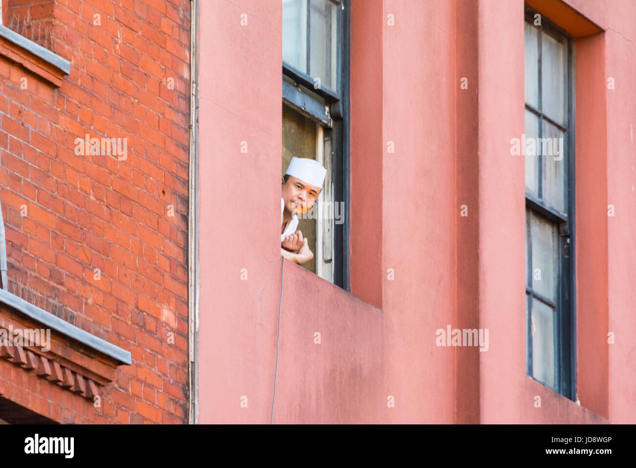 Un capo guardando fuori della finestra in Chinatown, Soho, London, Regno Unito Foto Stock