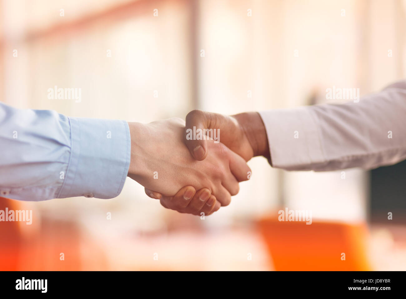 Stretta di mano tra africani e di un uomo caucasico Foto Stock