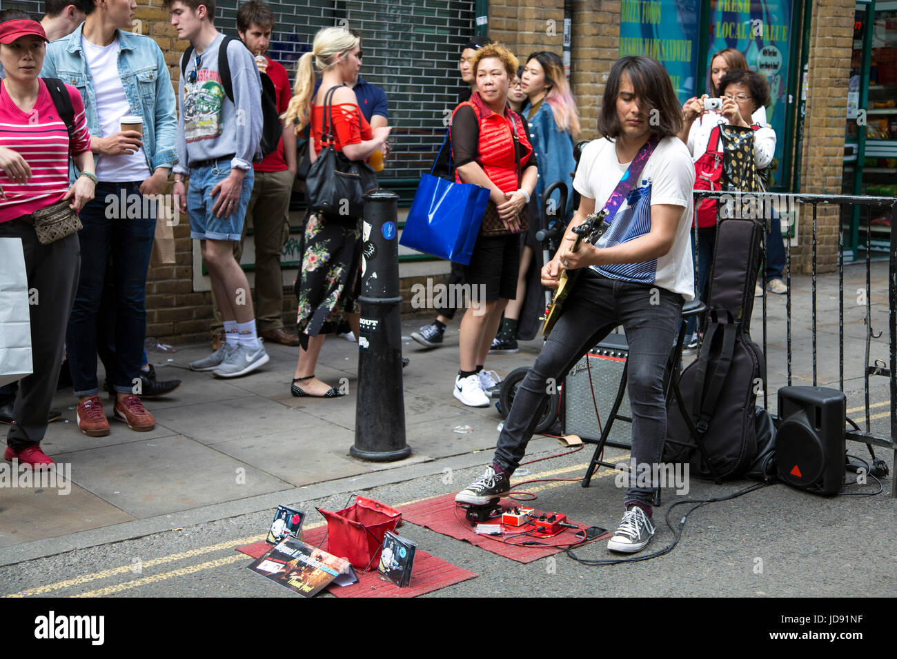 Un musicista busker suonando la chitarra in Brick Lane, East London, Regno Unito Foto Stock