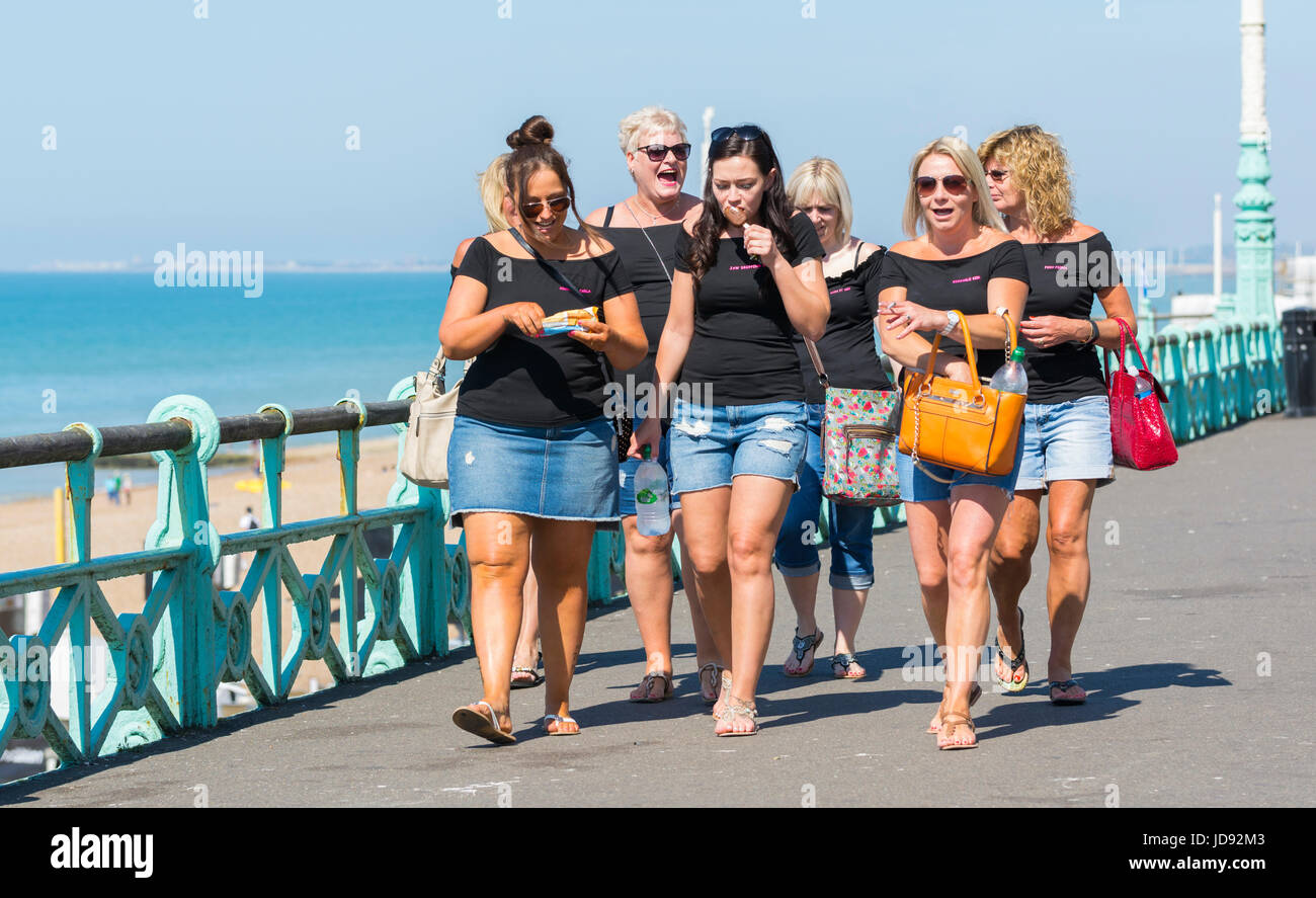 Hen party. Gruppo di giovane donna con la sposa per essere sulla loro parte di gallina a piedi lungo la passeggiata sul mare in una calda giornata di sole. Foto Stock