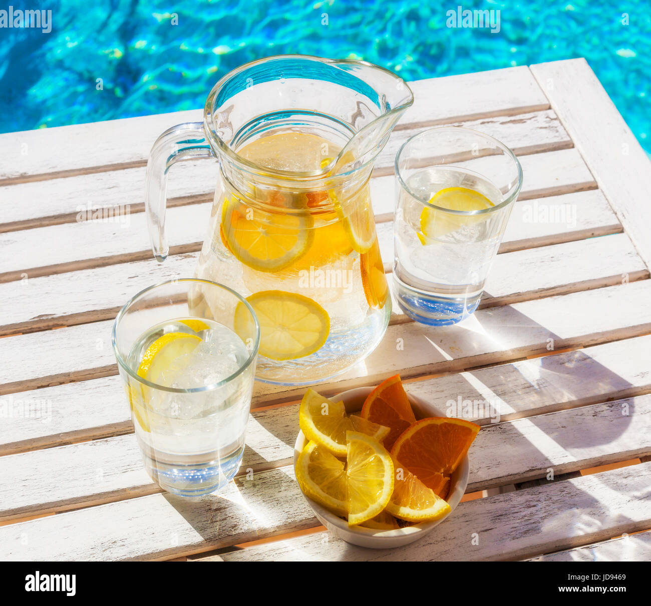 Aggiornamento ghiaccio acqua con limone e arancio presso la piscina in estate. Foto Stock