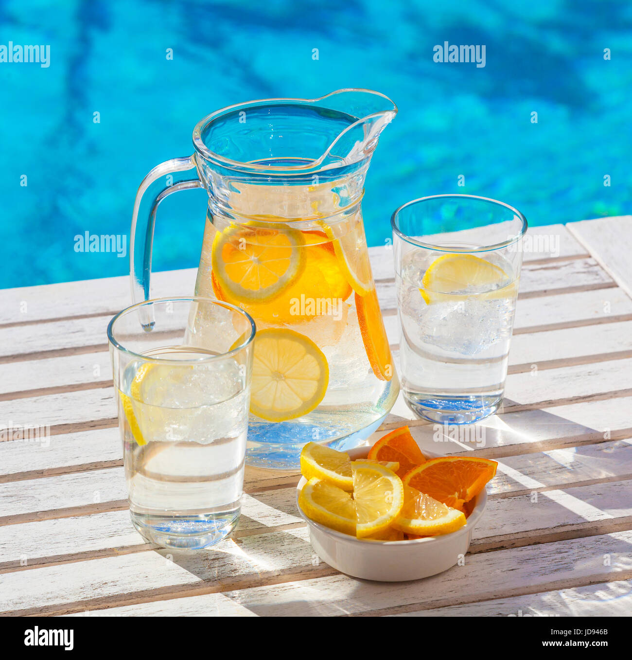 Un vaso e due bicchieri di ghiaccio refeshing acqua di idratazione in tempo caldo. Foto Stock