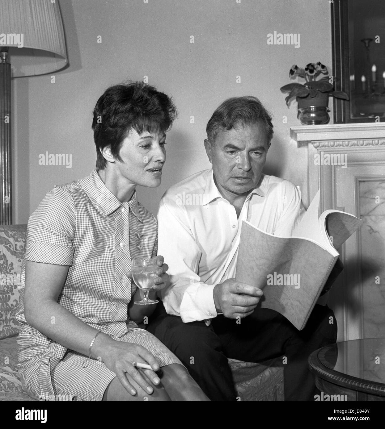L'attore James Mason - a fianco di autore Penelope Mortimer - come egli delibera sulla sceneggiatura di 'Il mangiatore di zucca", un nuovo film in cui egli è a stella con Anne Bancroft. Il film è basato su Penelope Mortimer's best-seller ed è stato adattato per lo schermo da Harold Pinter. Foto Stock
