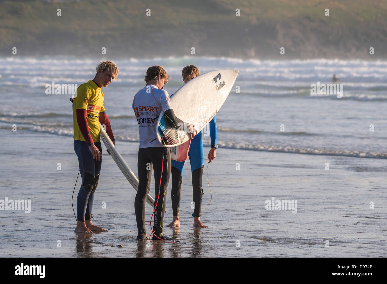 Tre surfers permanente sulla battigia prima di entrare in mare. Fistral Beach, Newquay Cornwall. Foto Stock