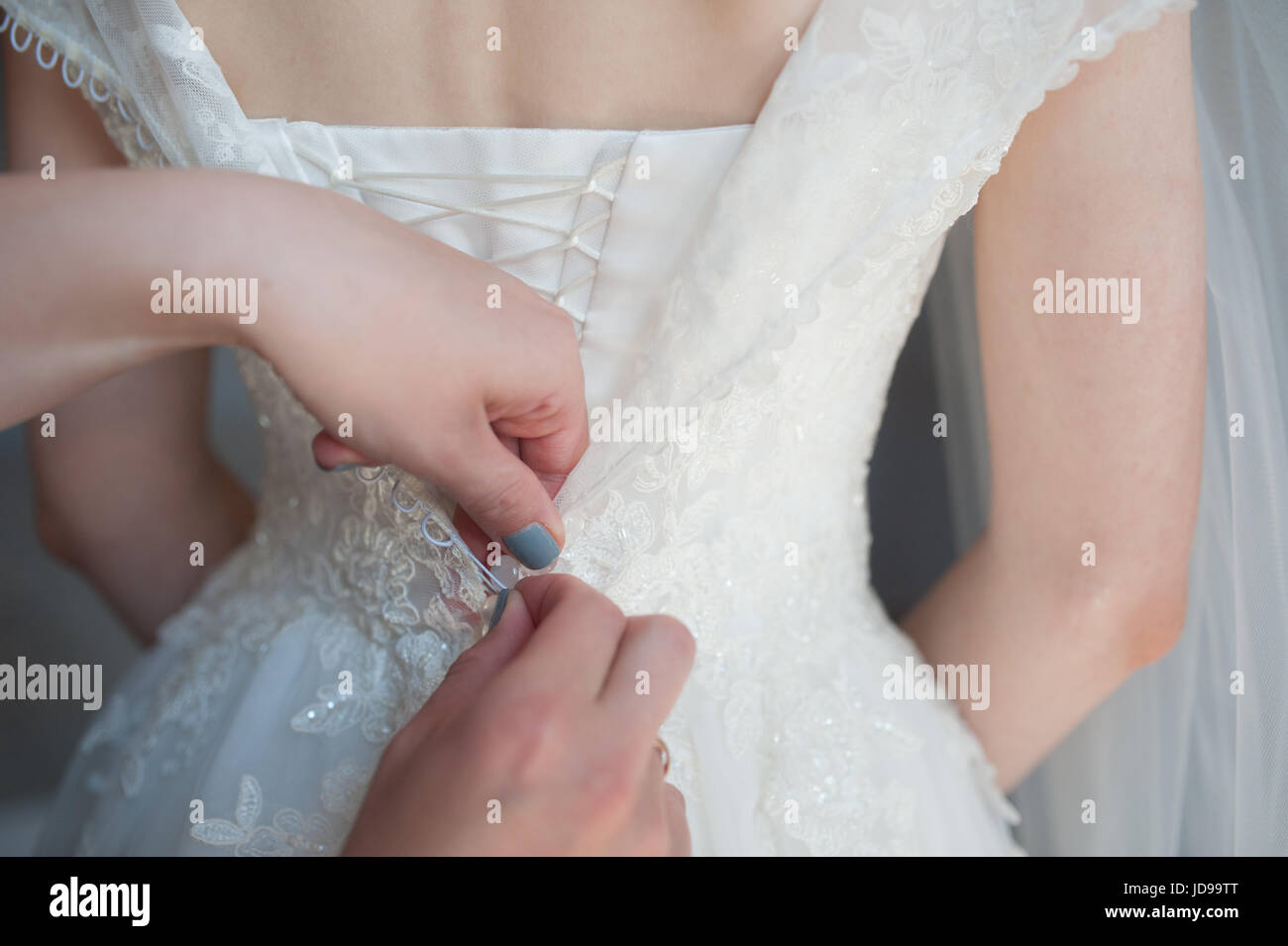 Il fissaggio del vestito, bottoni sulla sposa vestito della sposa, le spese abito da sposa, giorno di nozze Foto Stock