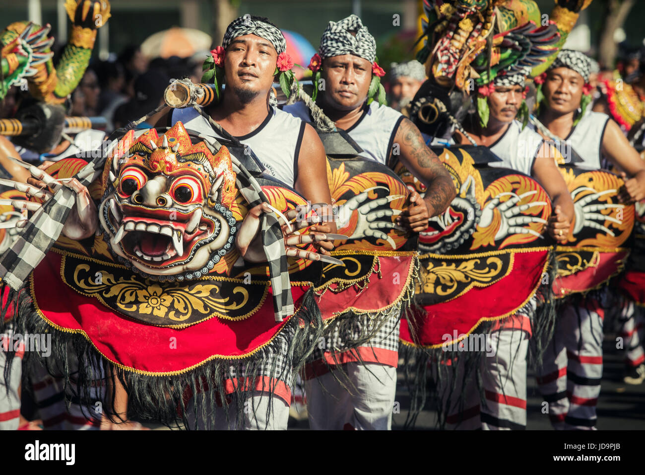 Culturale Balinese street parade durante il giorno di apertura del Bali Arts Festival 2017. Uomini indonesiani in processione con enorme spaventose maschere Balinese Foto Stock
