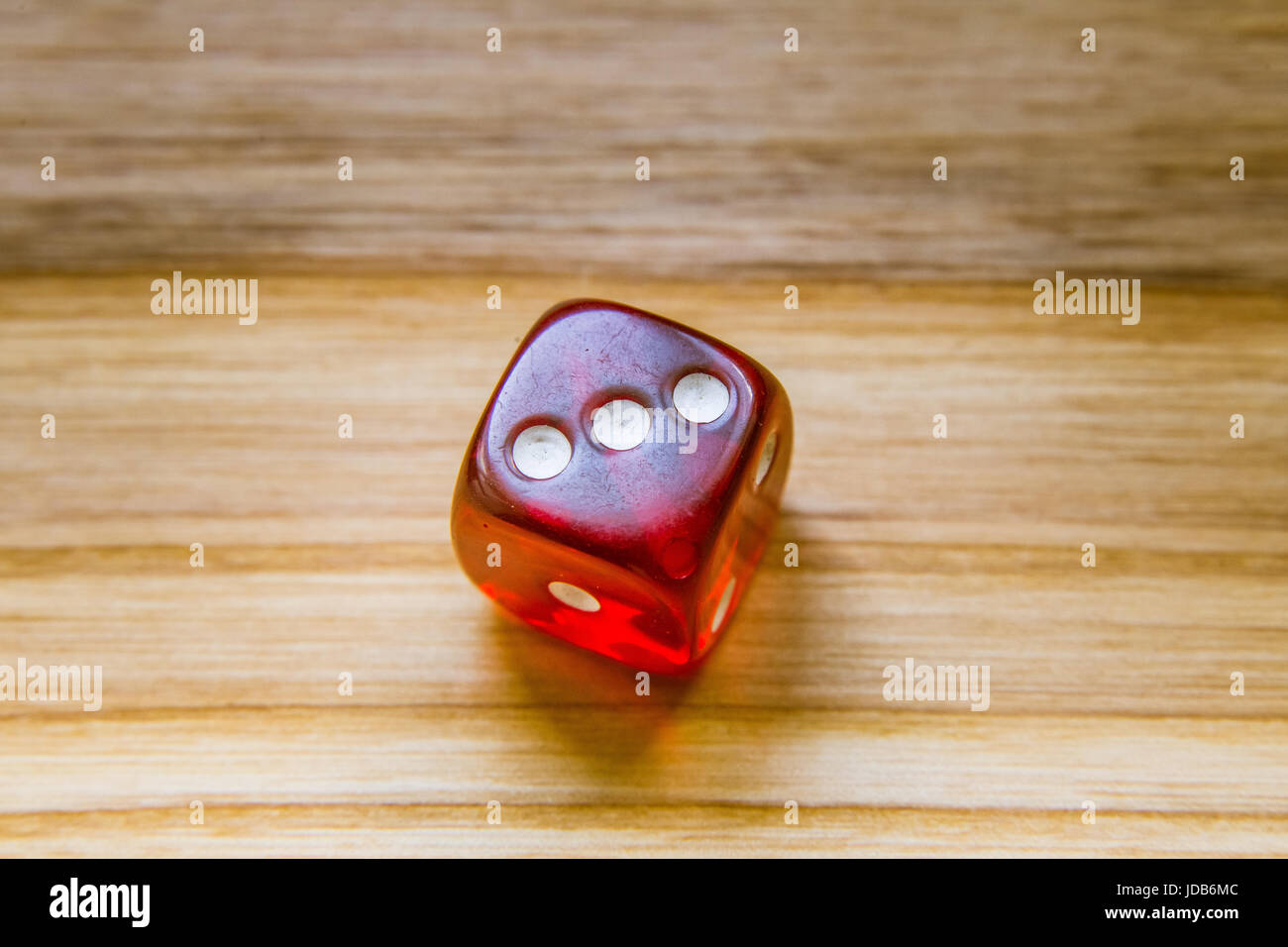 Un bellissimo vincere la riproduzione di dadi lanciati su un lato sul tavolo di legno Foto Stock