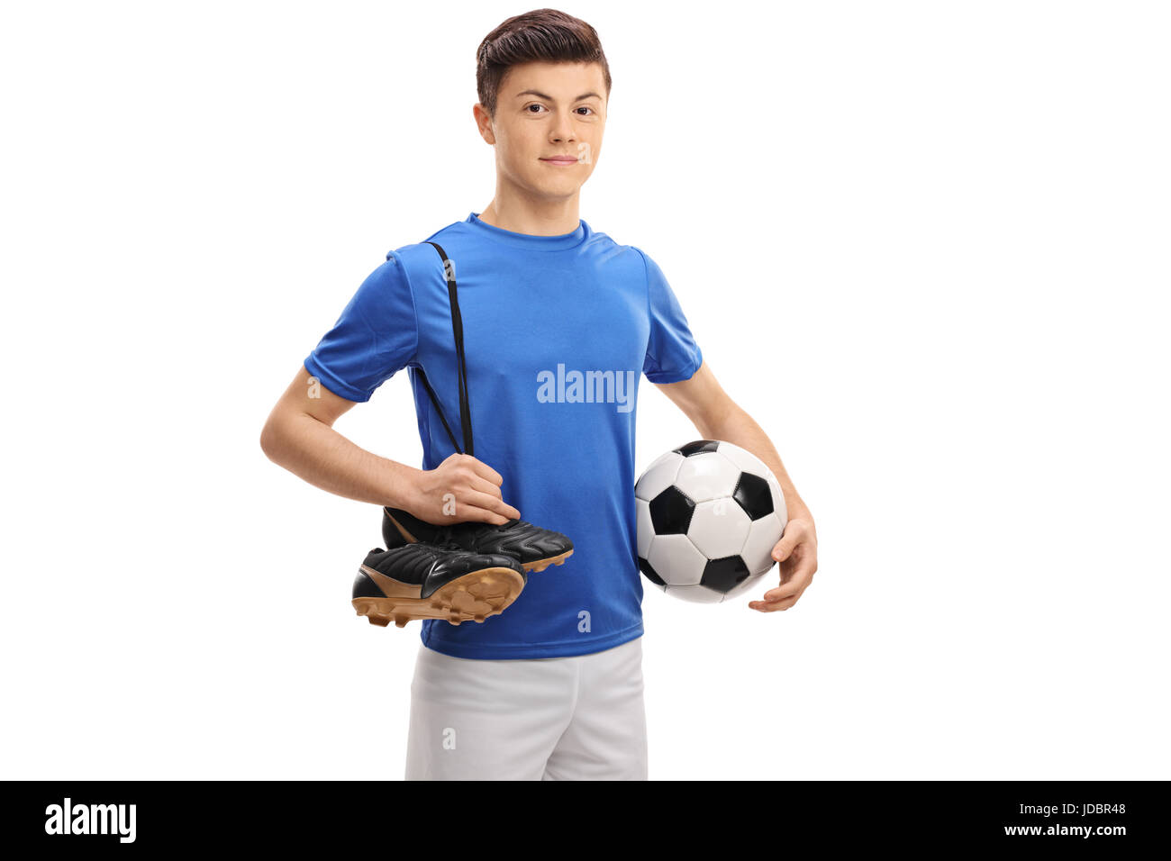 Teenage giocatore di calcio con un pallone da calcio e un paio di scarpe da calcio isolati su sfondo bianco Foto Stock