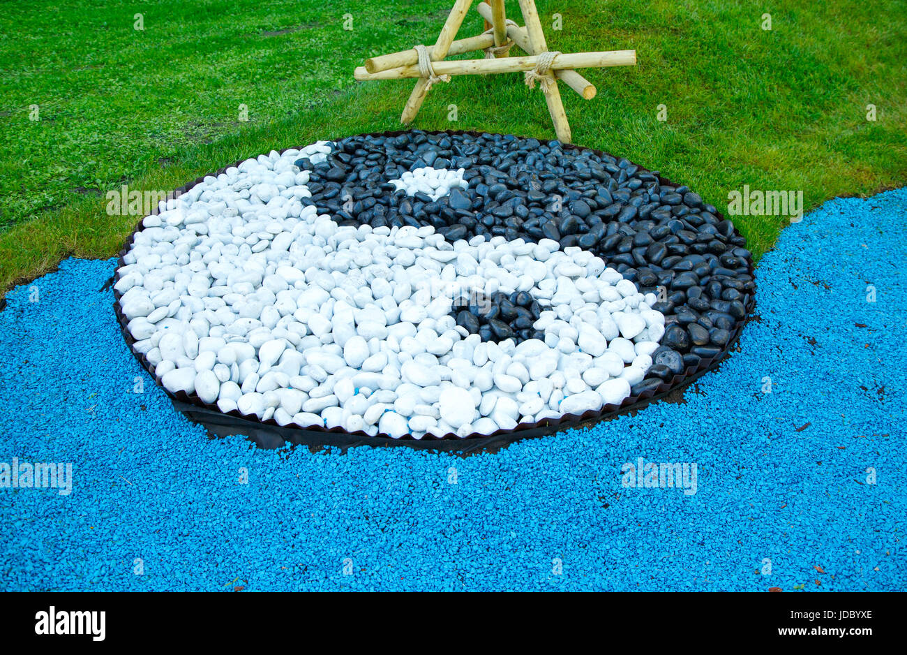 Segno di yin yang di cui al di fuori del nero e pietre bianche su un prato verde Foto Stock