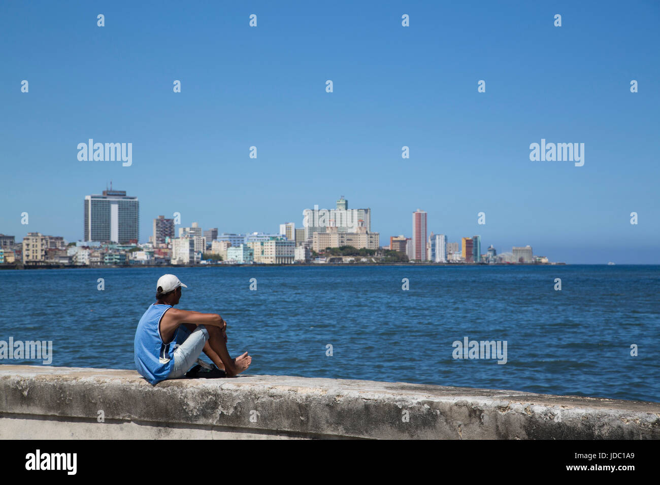 Uomo locale la visualizzazione dello skyline della città dal Malecon, Centro Habana, Havana, Cuba Foto Stock