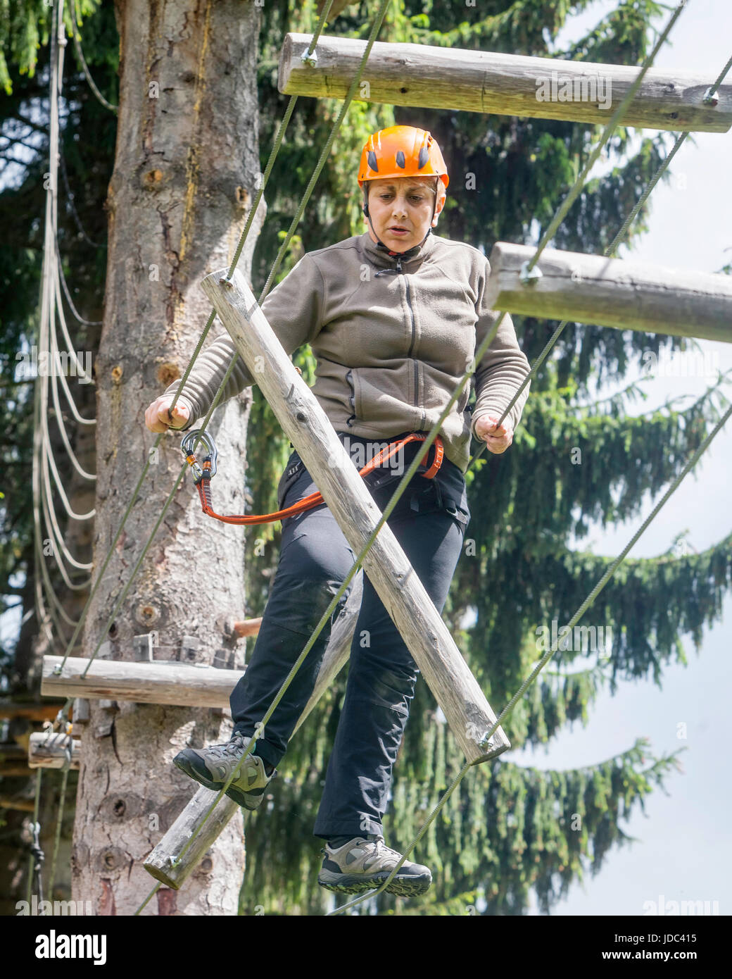 Tense rumeno donna turistica godendo di attività di arrampicata in montagna Retezat parco avventura su un giorno di estate Foto Stock