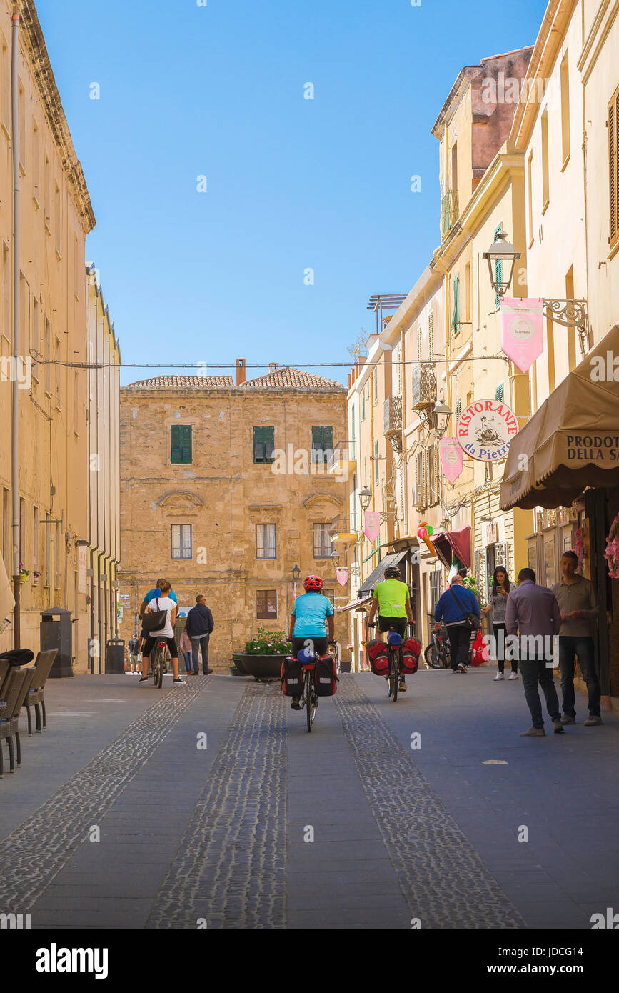 Sardegna ciclismo, vista di ciclisti in sella lungo una strada nei pressi di Porta Terra area nel centro storico della città di Alghero, in Sardegna. Foto Stock