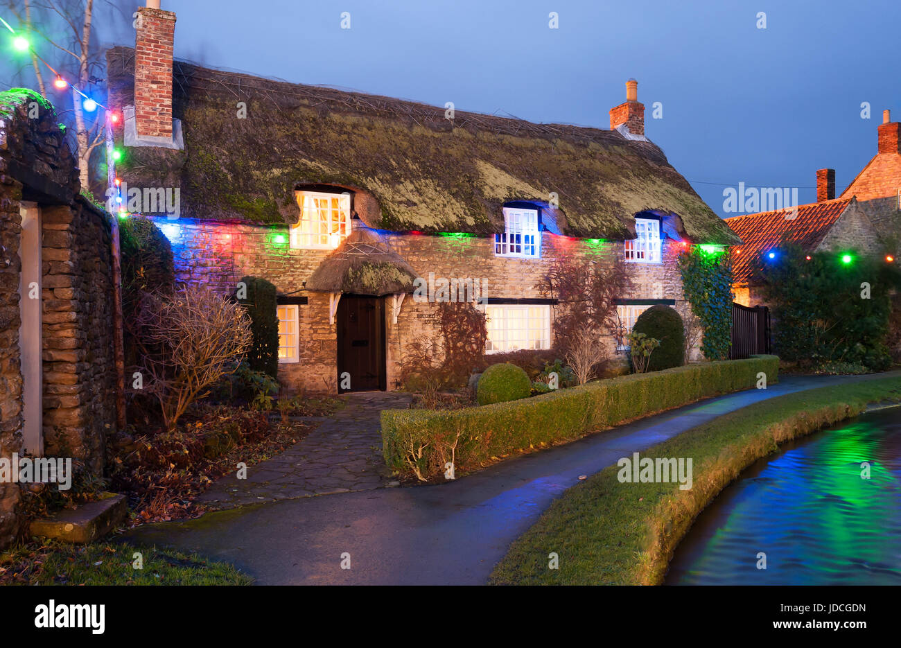 Le luci di Natale sul famoso cottage con il tetto di paglia a Thornton Dale Foto Stock