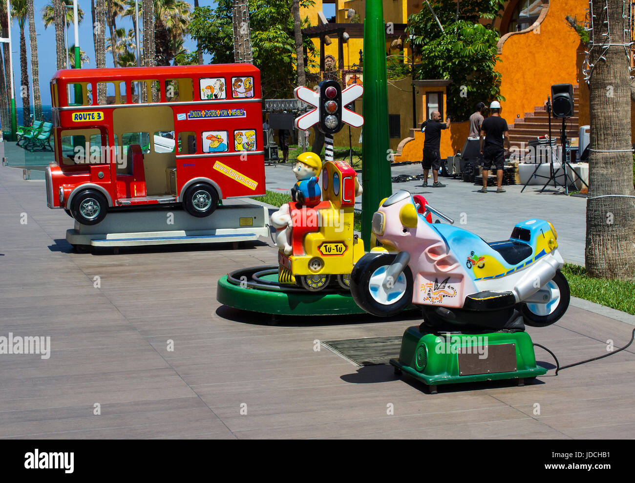 Una selezione di colorate giostre elettriche per bambini e bambini in un centro divertimenti in un centro commerciale locale a Playa Las Americasi Foto Stock