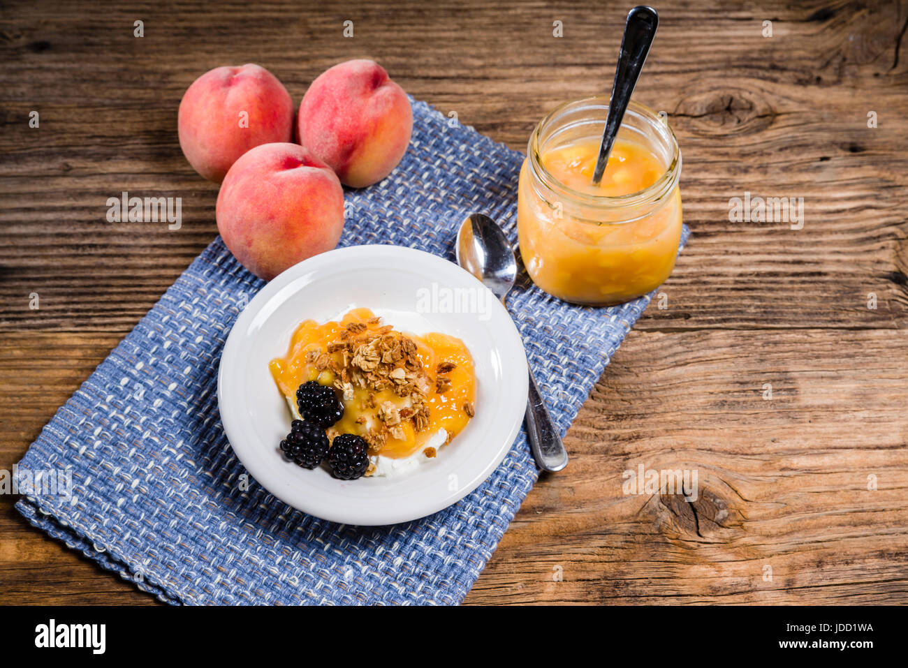 Mature succose pesche gialle e yogurt sul tavolo rustico Foto Stock