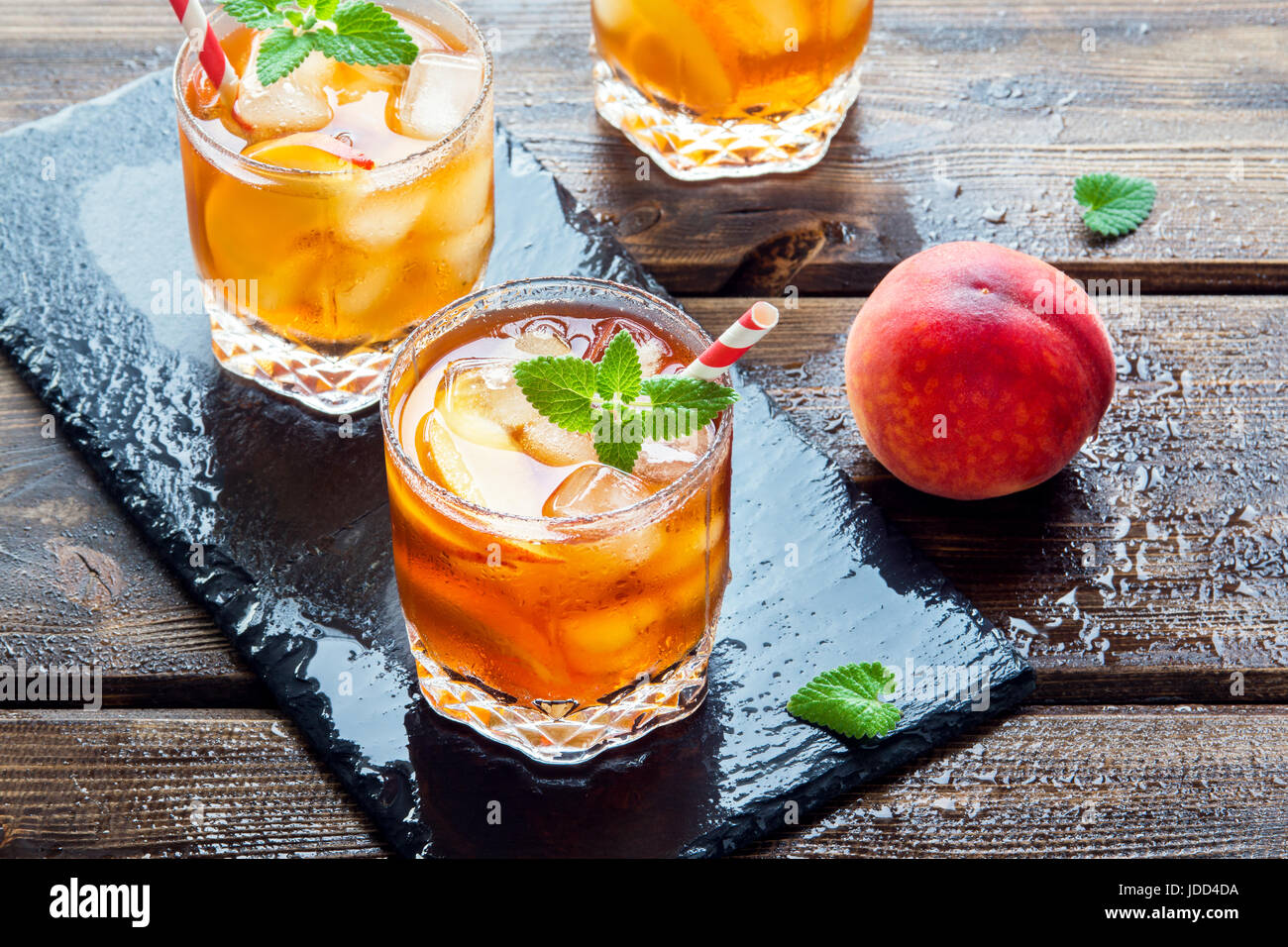 Peach tè freddo. Tè freddo con fette di pesche, menta e cubetti di ghiaccio da vicino. In casa dissetante bevanda estiva. Foto Stock