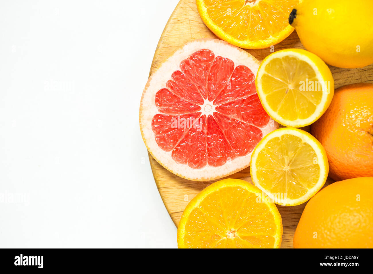 La vitamina C frutta - limone, arancio e pompelmi le fette su woden tagliere su sfondo bianco Foto Stock
