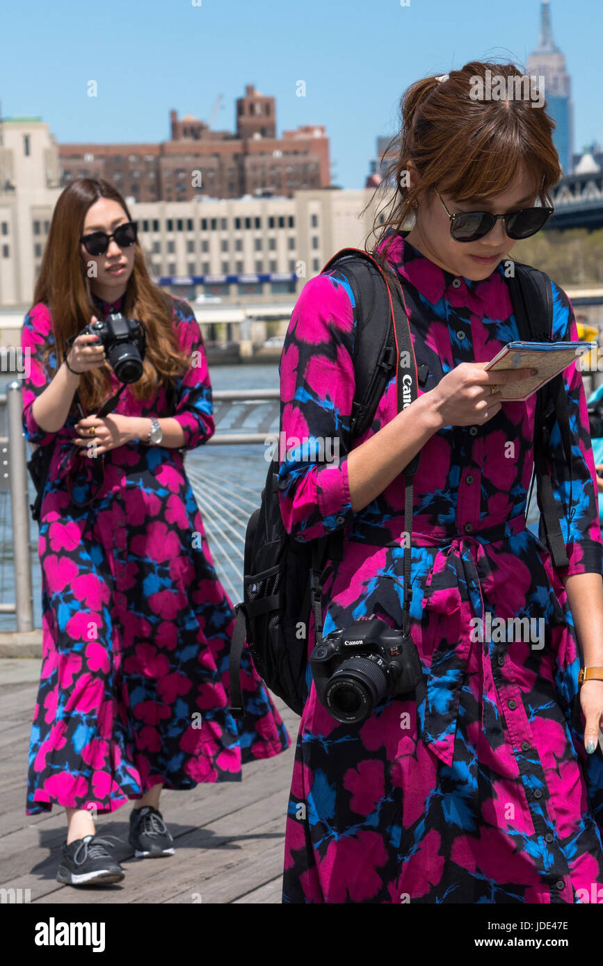 La città di New York, Stati Uniti - Aprile 23, 2017: due donne asiatiche turisti medicazione nello stesso modo a piedi a Dumbo waterfront. Foto Stock