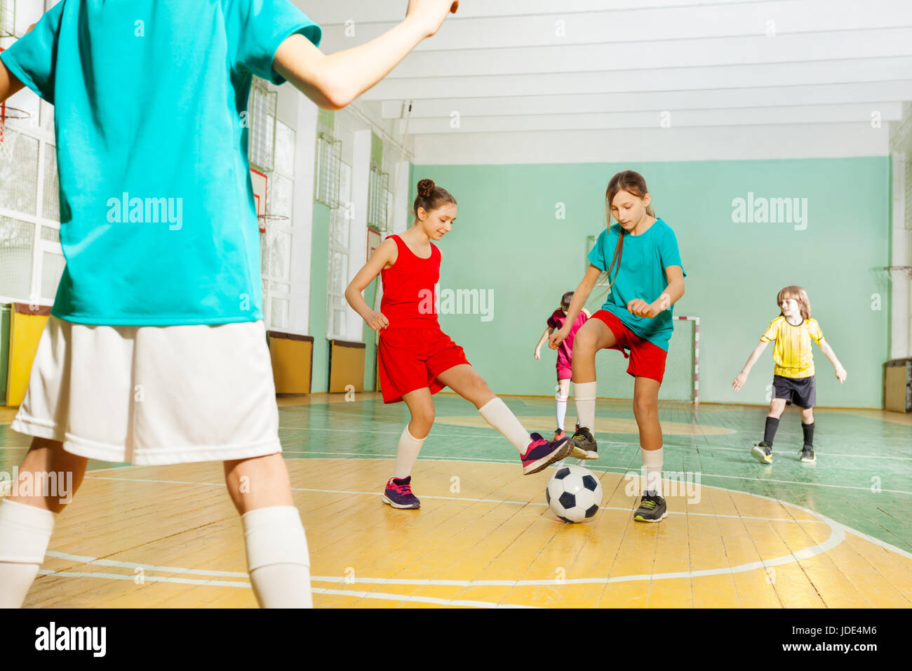 Ritratto di preteen i ragazzi e le ragazze di calcio per la formazione nella scuola di sport hall Foto Stock