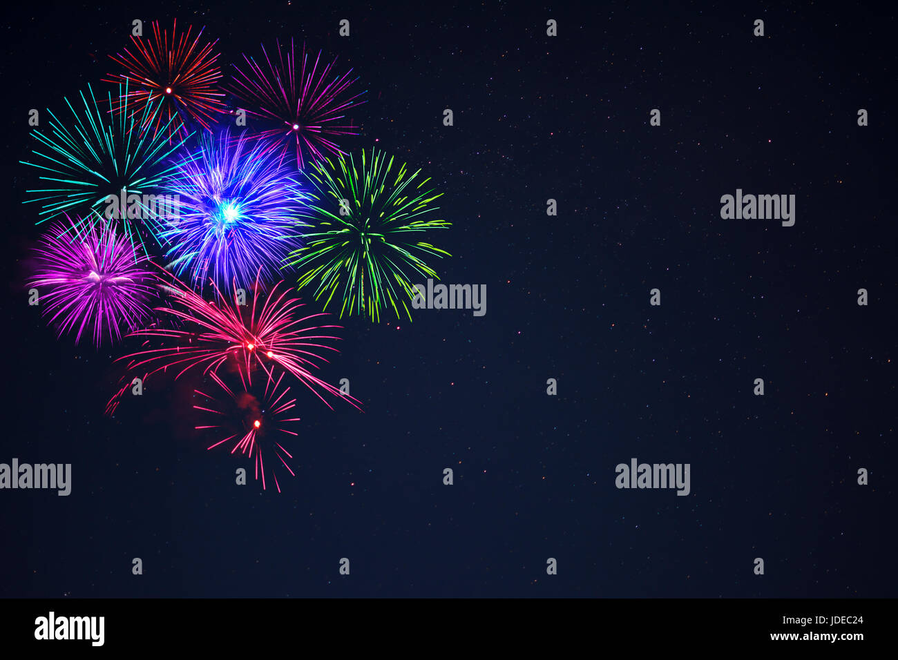 Bella purpe rosa blu verde celebrazione fuochi d'artificio ubicata sulla sinistra oltre il cielo notturno, copia dello spazio. Giorno di indipendenza, 4 luglio, le vacanze di Capodanno Foto Stock